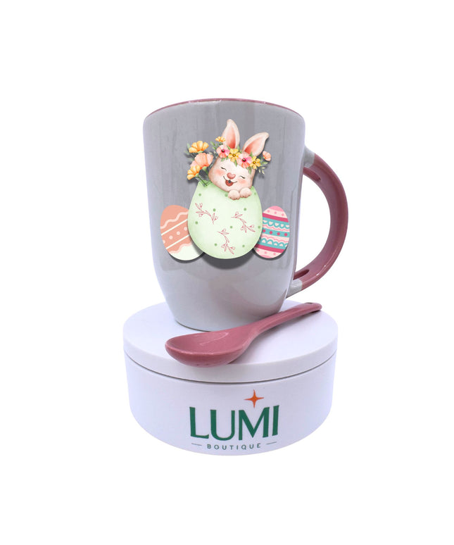 Easter-themed mug with a rabbit design and matching spoon on a white background, featuring the LUMI Boutique brand.