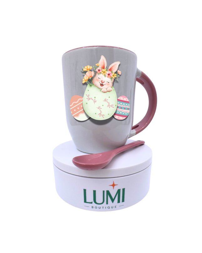 Easter-themed mug with a rabbit design and matching spoon on a white background, featuring the LUMI Boutique brand.