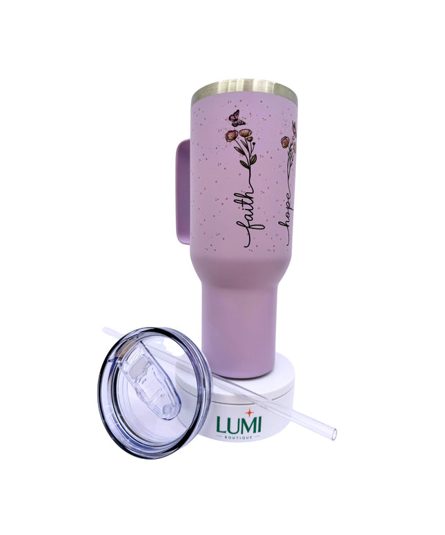 Pink tumbler with floral design and 'faith' text, featuring Lumi logo.