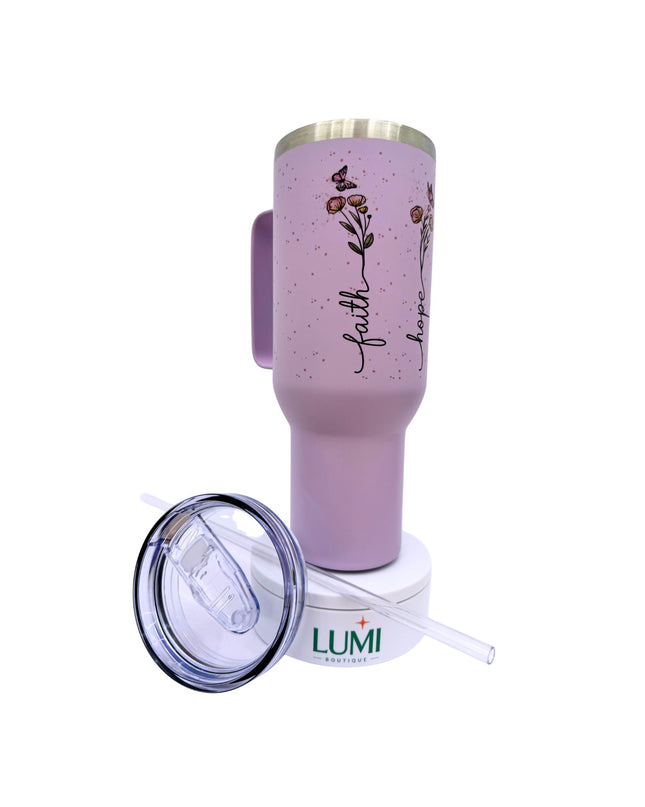 Pink tumbler with floral design and 'faith' text, featuring Lumi logo.