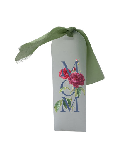 Decorative tag with 'MOM' and floral design on a white background