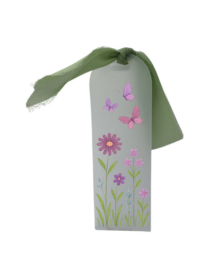 bookmark with floral designs and a green ribbon on a white background