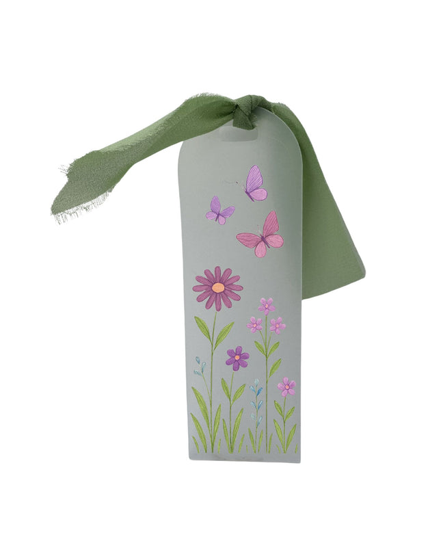bookmark with floral designs and a green ribbon on a white background