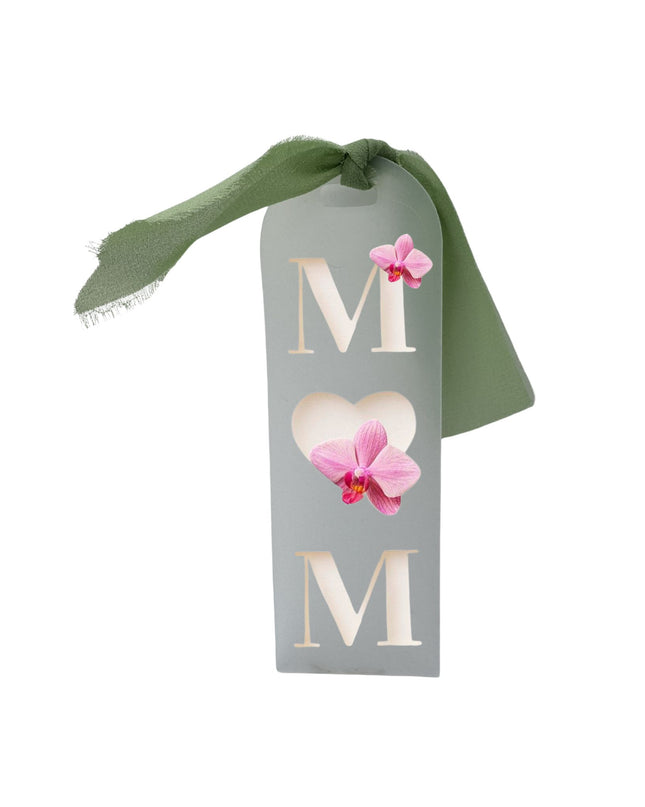 Decorative tag with 'M' and pink flowers on a white background
