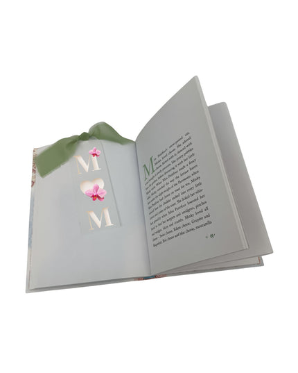 Open book with decorative letters spelling 'MOM' on a white background