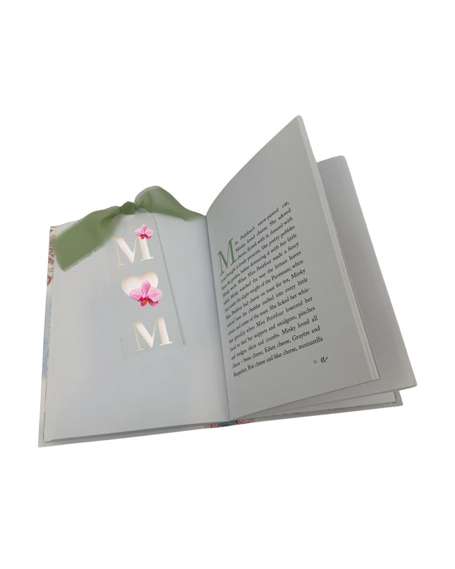 Open book with decorative letters spelling 'MOM' on a white background