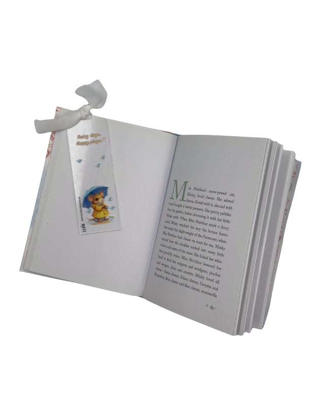 Open book with a bookmark featuring a teddy bear illustration on a white background