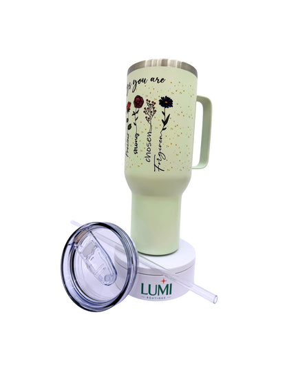 Light green mug with floral designs and text, featuring a Lumi straw lid on a white background
