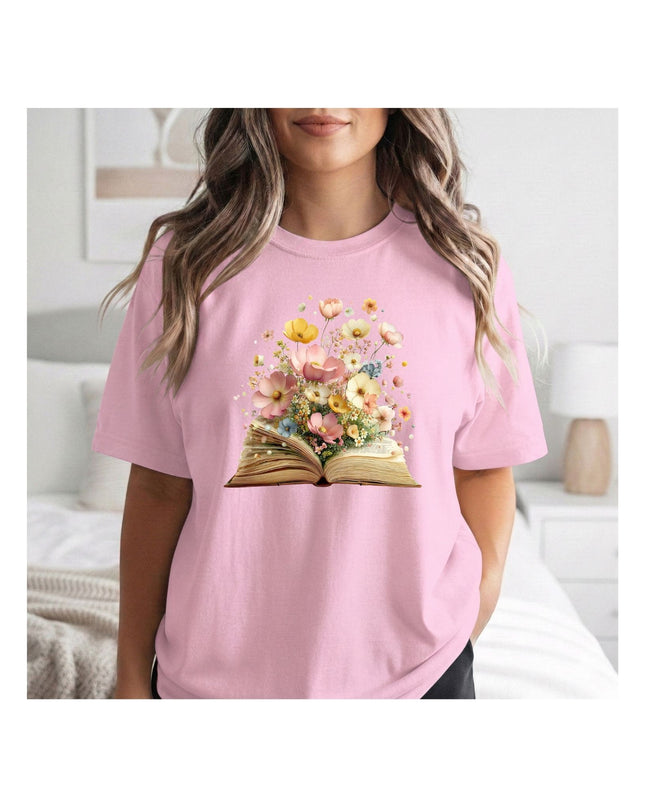 Person wearing a pink t-shirt with a floral book design in a bedroom setting