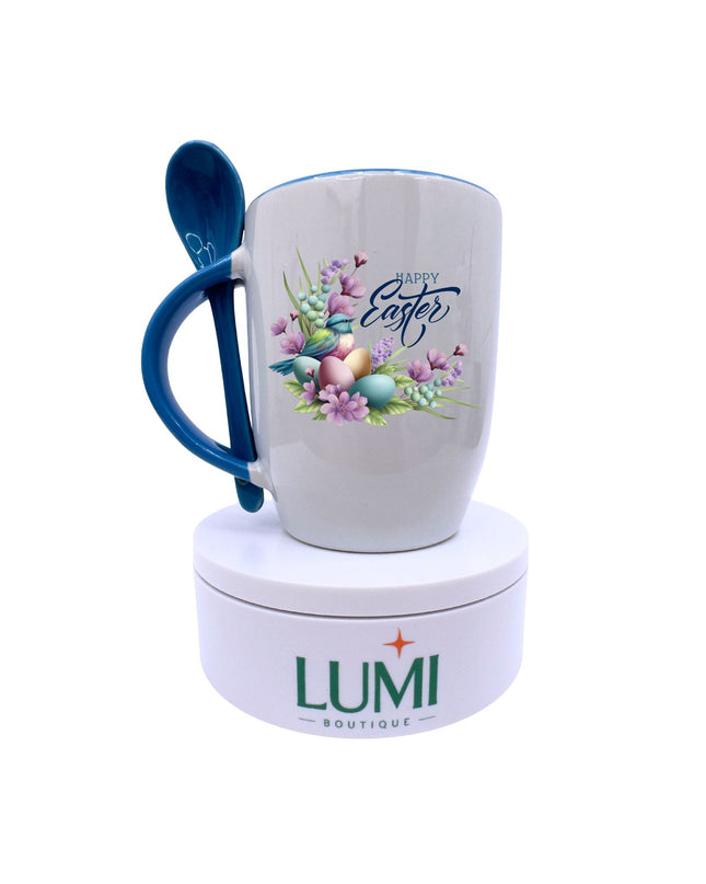 Easter-themed mug with blue handle and spoon, featuring floral and egg design, on a white background with Lumi Boutique branding.