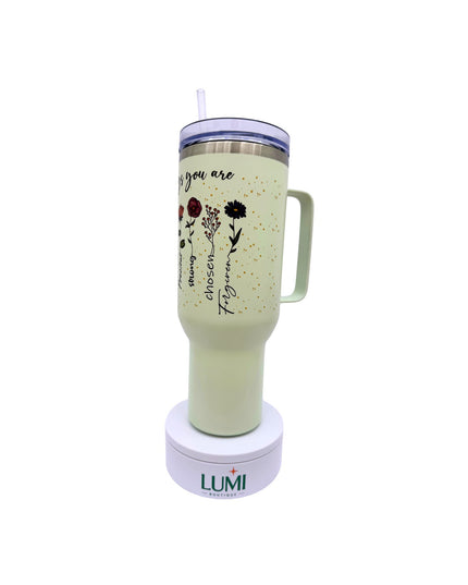Light green tumbler with floral design and text on a white background, featuring the LUMI logo.