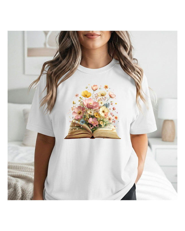 Person wearing a white t-shirt with a floral book design in a room.