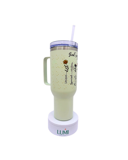 Light green tumbler with handle and straw on a white background