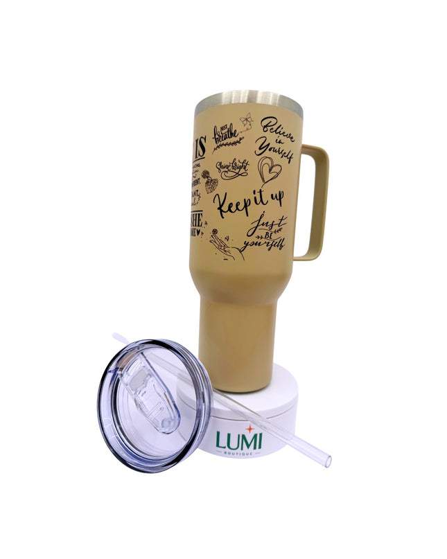 Gold travel mug with motivational quotes and a matching straw lid on a white background