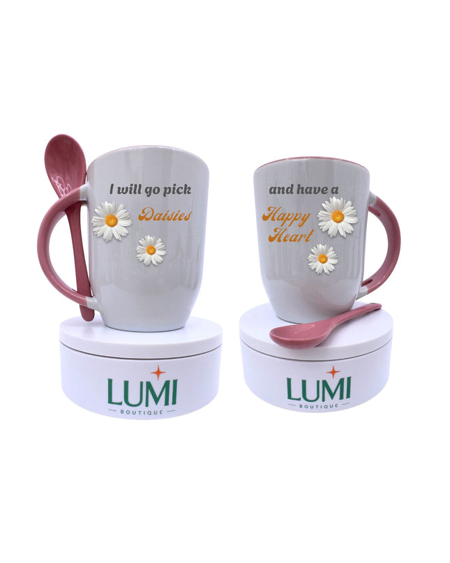 Two mugs with pink handles and spoons, featuring floral designs and text, on LUMI containers.