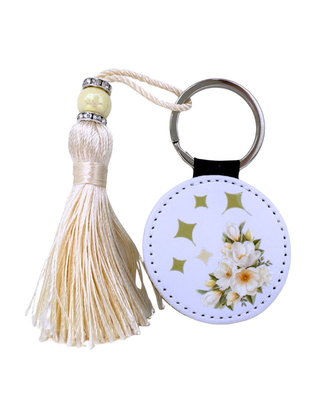 Keychain with tassel and floral design on a white background