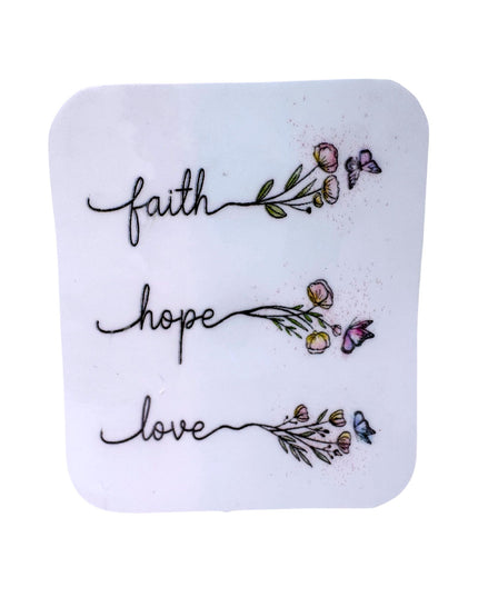 Square white tile with 'faith hope love' text and floral designs on a white background