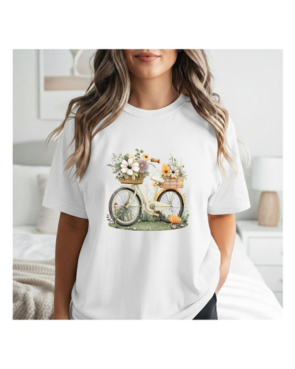 White t-shirt with a bicycle and flower design worn by a person in a bedroom setting