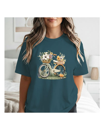 Person wearing a teal t-shirt with a bicycle and flower design.
