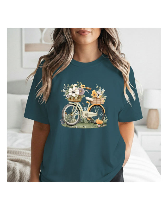 Person wearing a teal t-shirt with a bicycle and flower design.