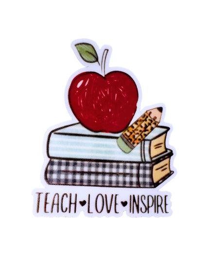 Sticker with an apple on books, a pencil, and 'Teach Love Inspire' text on a white background