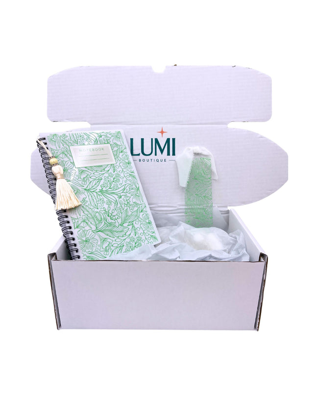 Box from LUMI Boutique with a green notebook and decorative item on a white background