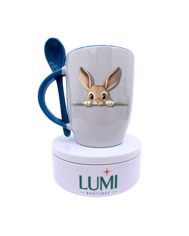 Mug with rabbit design and blue handle, featuring Lumi Boutique logo.