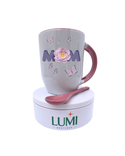 Mug with 'MOM' and flower design, pink spoon, on white background, LUMI Boutique branding.