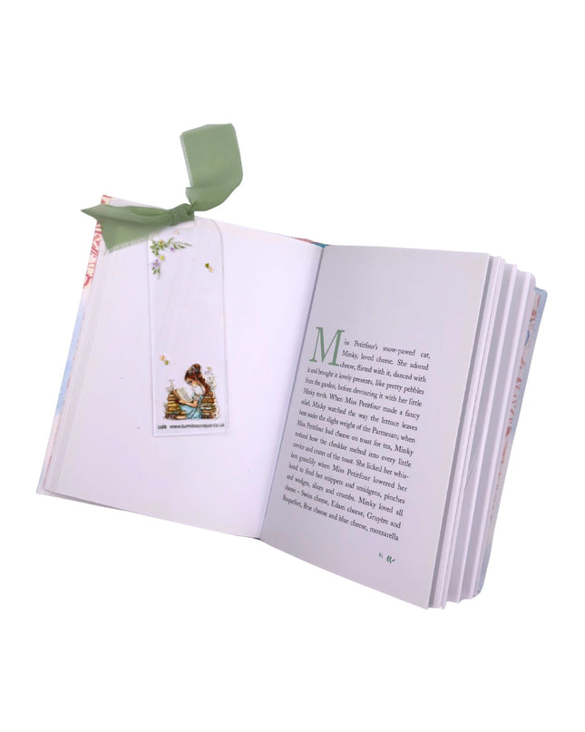 Open book with a bookmark featuring a cartoon character on a white background