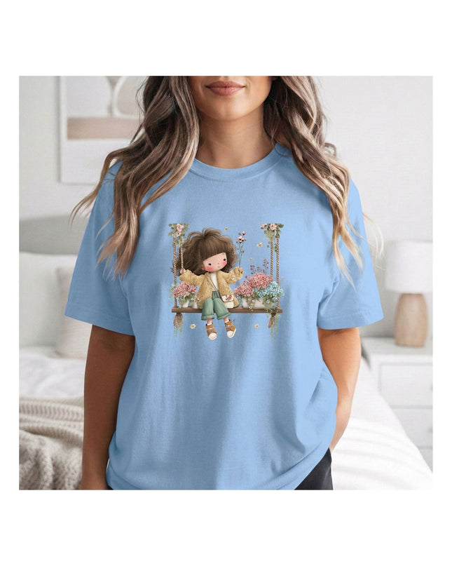  a light blue t-shirt with a graphic design of a girl on a swing.