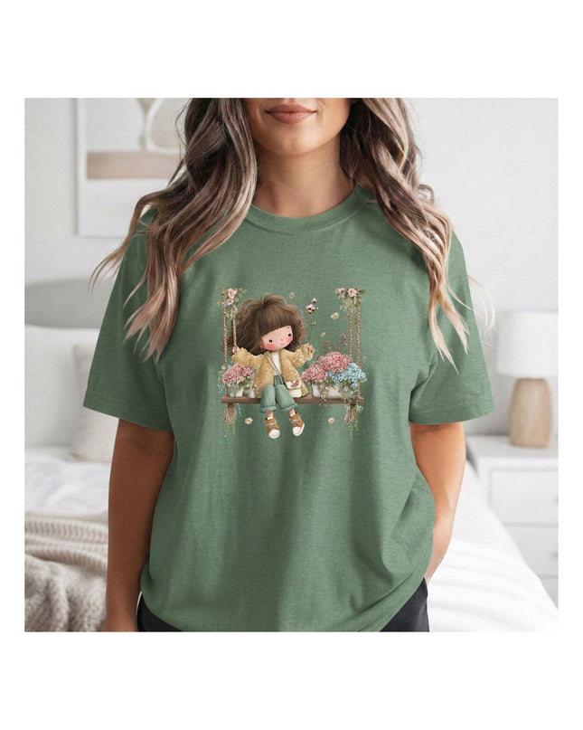 a green t-shirt with a graphic design of a girl on a swing.