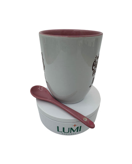 White mug with red interior and spoon on a white base with LUMI branding.