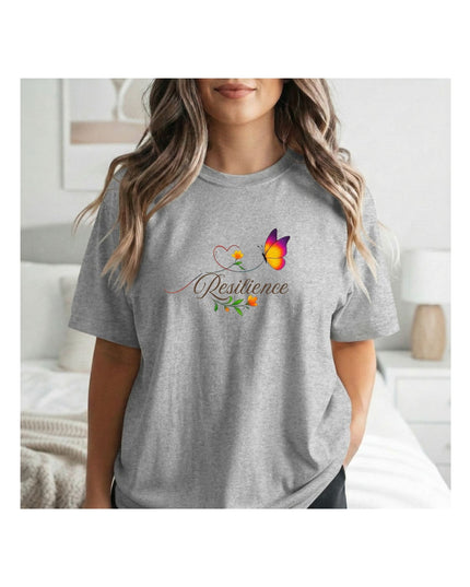 Person wearing a gray t-shirt with a colorful design and the word 'Resilience' on it, standing in a bedroom.