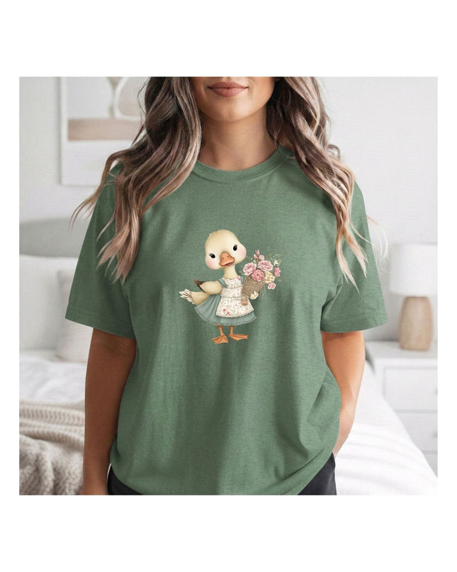 Person wearing a green t-shirt with a cartoon duck design holding flowers.