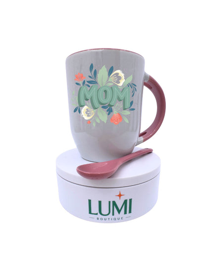 Gray mug with 'Mom' and floral design, pink handle, and matching spoon on a white base with LUMI Boutique branding.