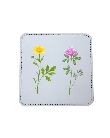 Square coaster with floral designs on a light blue background