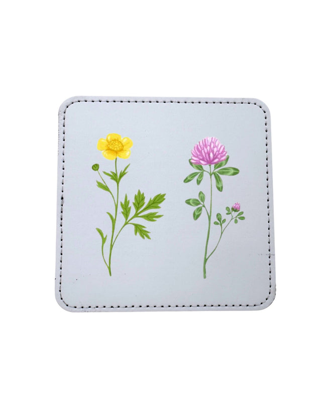 Square coaster with floral designs on a light blue background