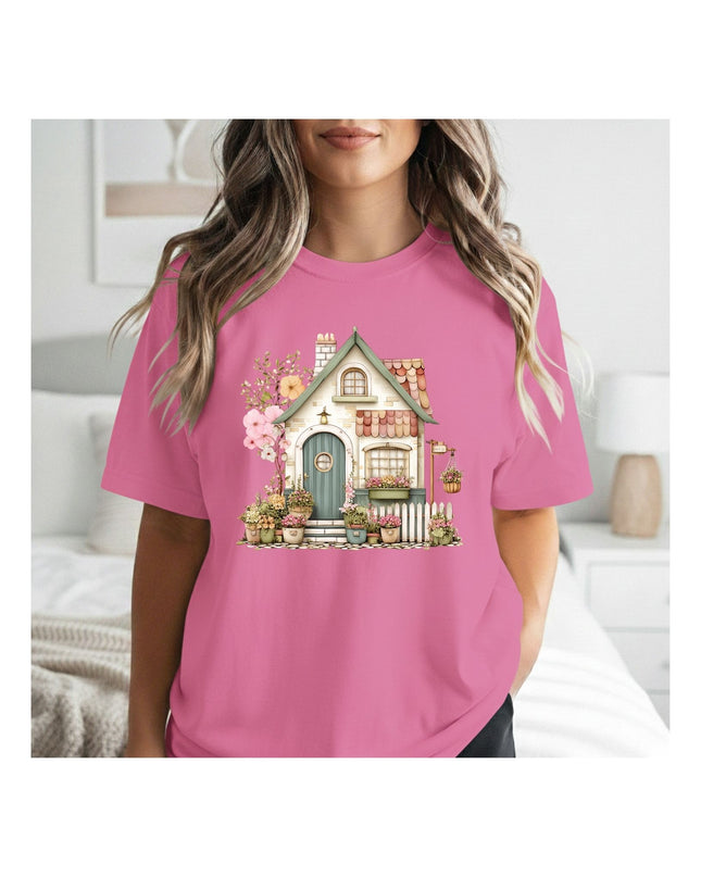  a pink t-shirt with a house graphic 