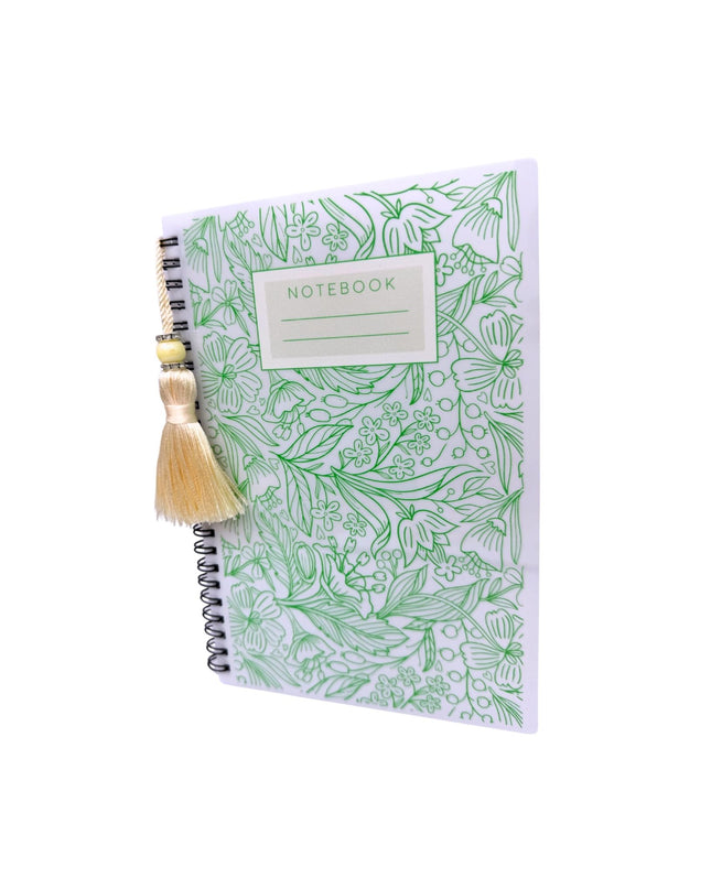 Notebook with green floral pattern and a decorative item on a white background