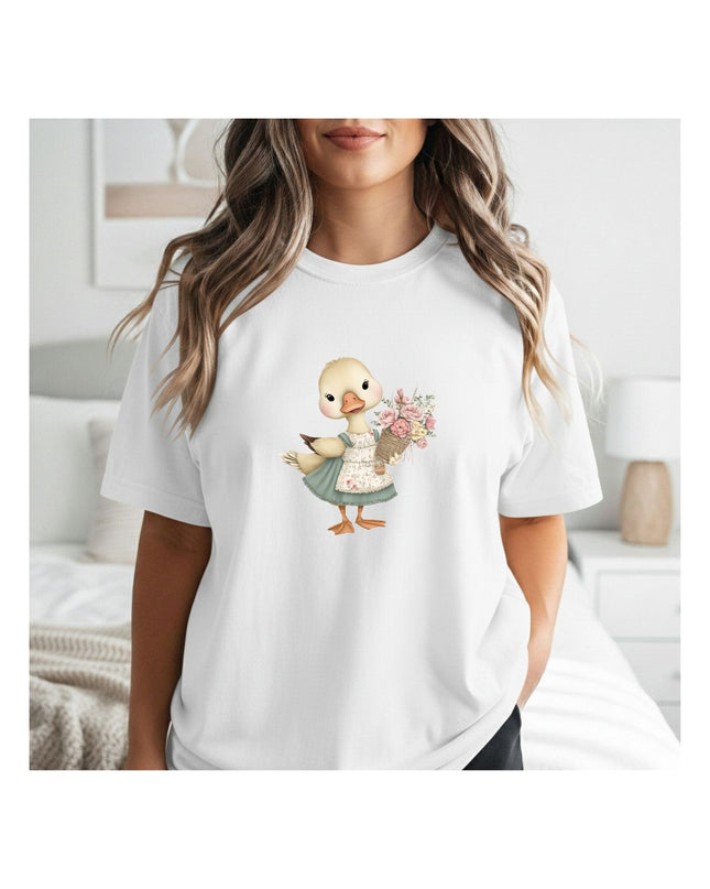 Person wearing a white t-shirt with a cartoon duck design holding flowers.