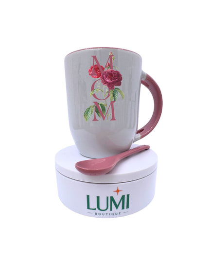 White mug with pink handle and floral design, accompanied by a pink spoon on a white base with LUMI Boutique logo.