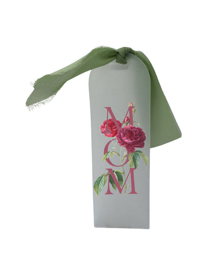 Decorative tag with 'MOM' and floral design on a white background