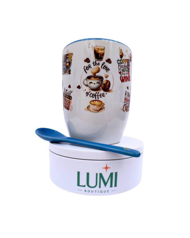 Mug with coffee-themed design and blue spoon on a white background, featuring the LUMI Boutique brand.