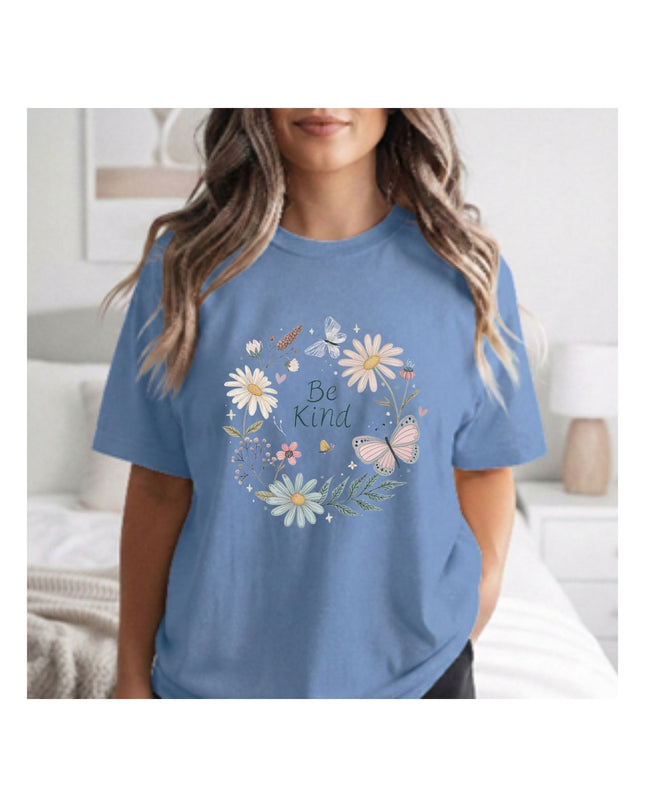 Person wearing a blue t-shirt with floral design and 'Be Kind' text.