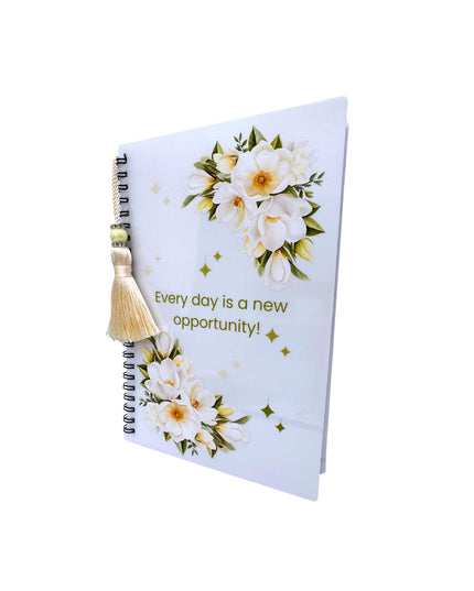 Notebook with floral design and motivational quote on a white background