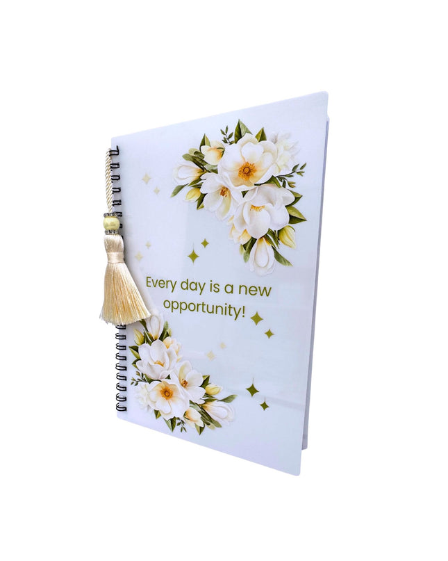 Notebook with floral design and motivational quote on a white background