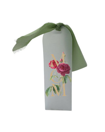 Decorative white tag with floral design and green ribbon on a white background