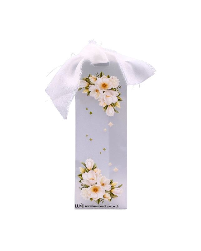 Gift bag with floral design and white bow on a white background